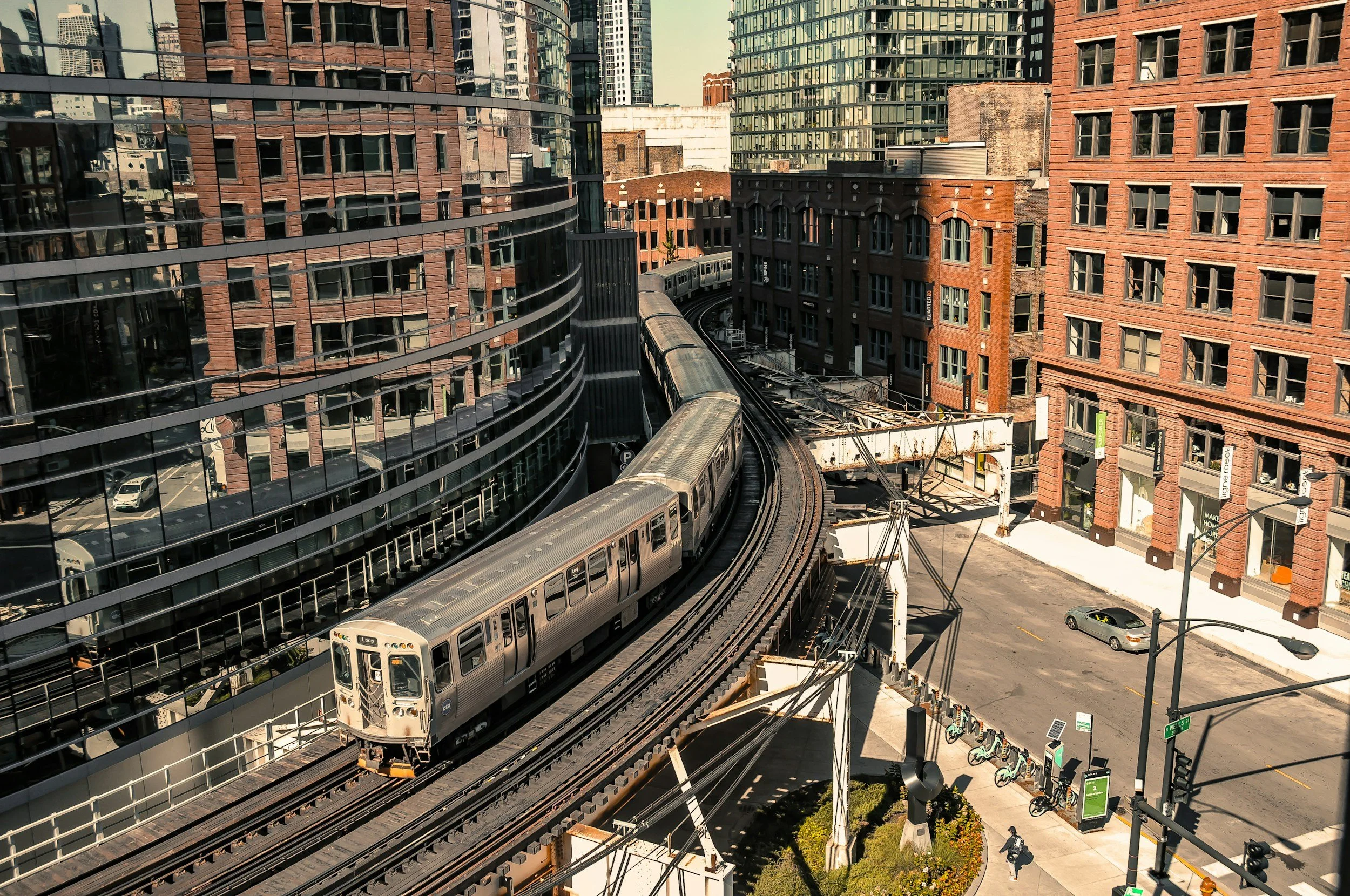 A CTA L train curving between buildings, seen from above
