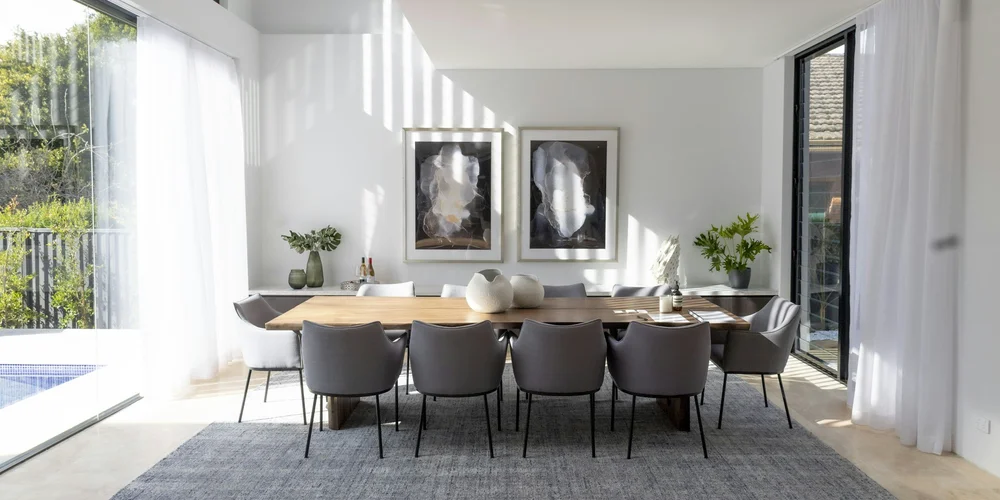 A bright, staged dining room with a long wood table