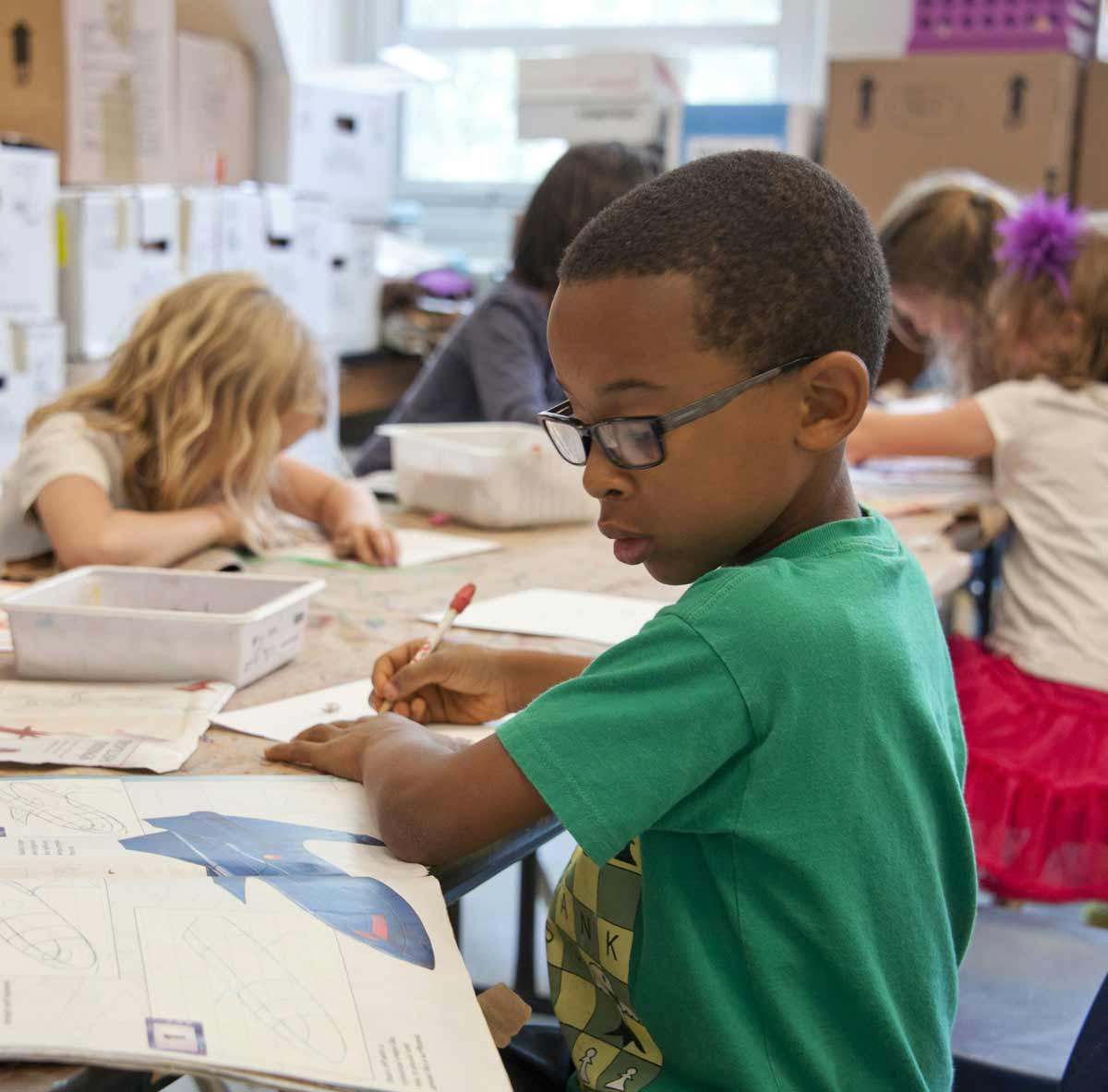 a young boy works in a classroom